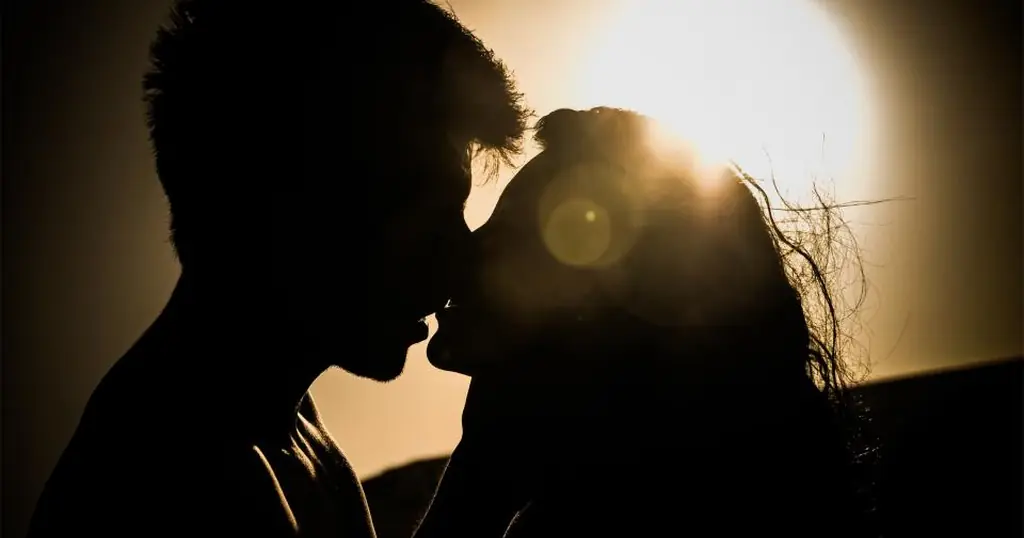 Plan cul en Suisse: un couple sur le point de s’embrasser, à contre-jour au coucher du soleil