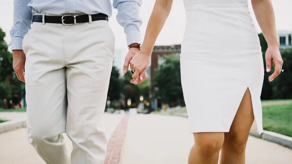 Rencontre plan cul à Crans-Montana: un couple qui marche main dans la main, robe blanche