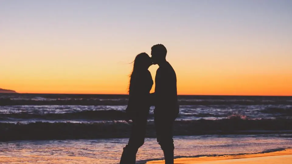 Rencontre plan cul à Lausanne: un baiser en silhouette sur la plage au crépuscule