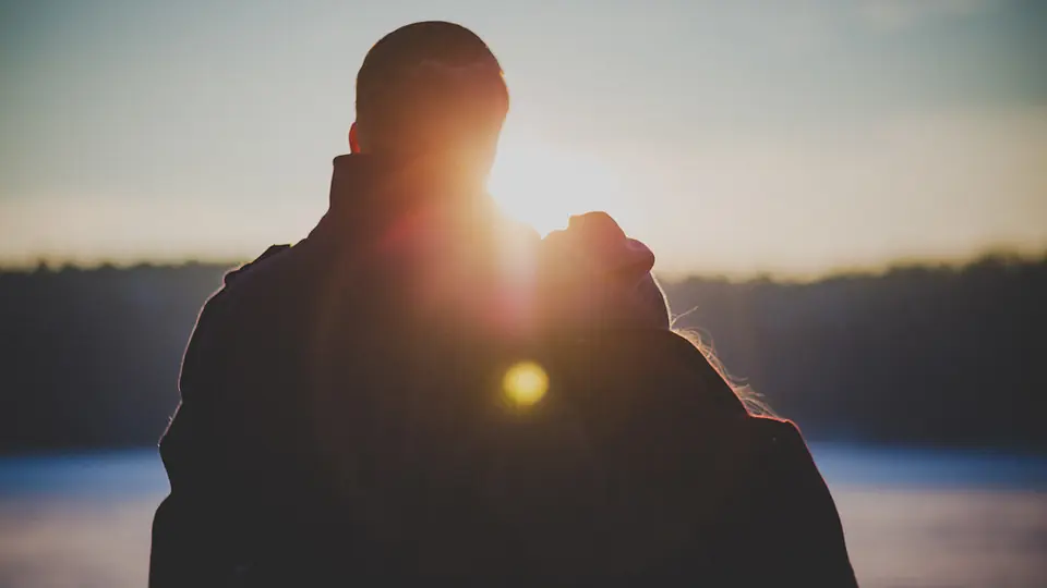 Rencontre plan cul à Meyrin: un couple enlacé à contre-jour au coucher du soleil