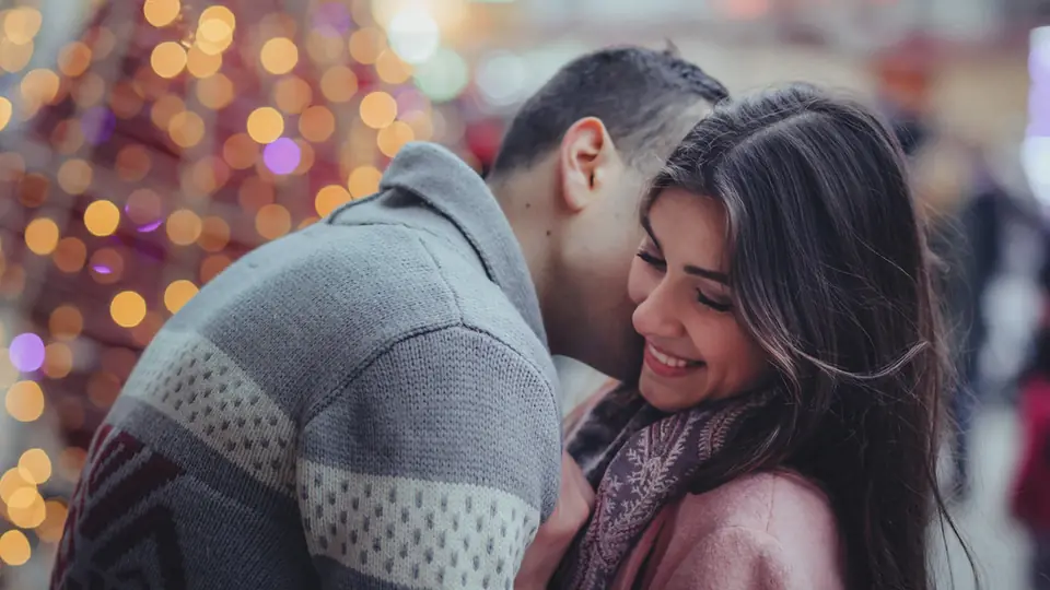Rencontre plan cul à Morges: un couple joue contre joue devant des lumières de fête