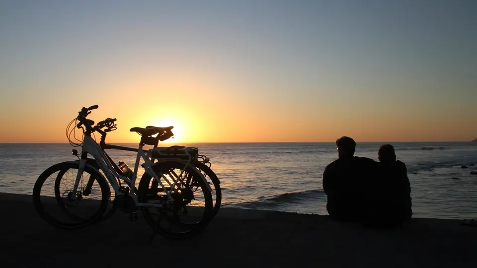 Rencontre plan cul à Moutier: un couple assis sur la plage au coucher du soleil