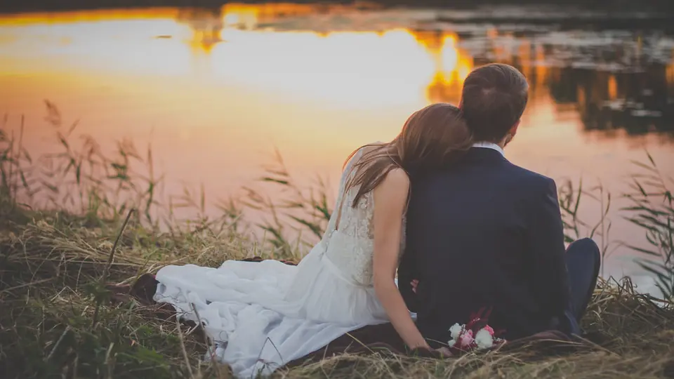 Rencontre plan cul à Renens: un couple assis au bord de l’eau au coucher du soleil