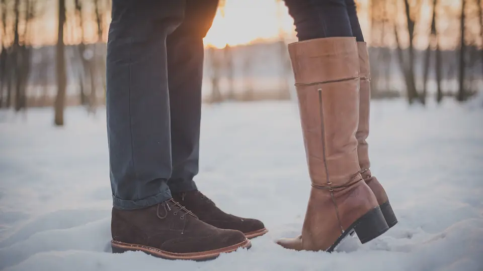 Rencontre adulte en Suisse: un couple se rapproche pour un baiser dans la neige
