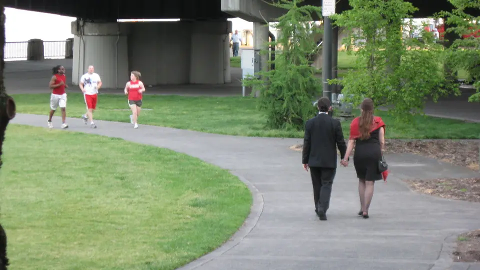Un couple se promène dans un parc public fréquenté, un bon cadre pour un premier rendez-vous